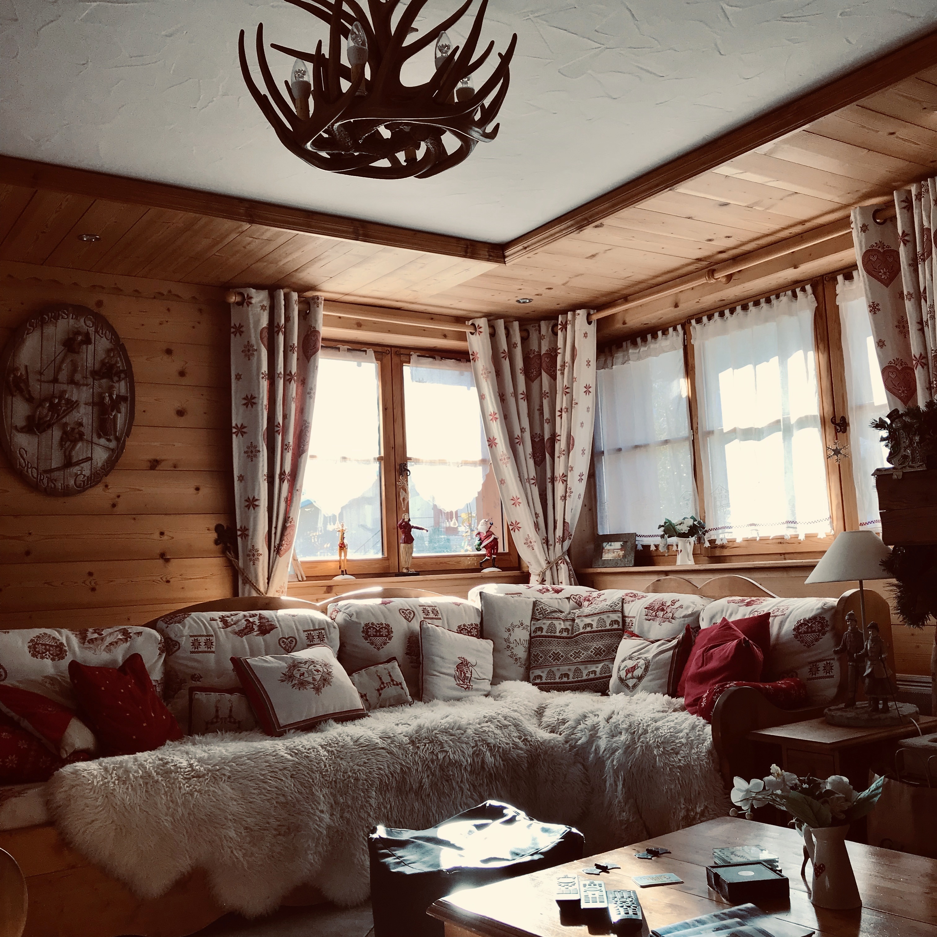 Chalet Champêtre living room with a corner sofa, traditional wooden interiors and sunlit windows